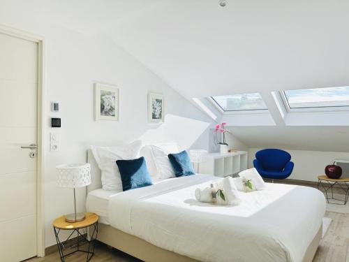 une chambre avec un grand lit blanc avec des oreillers bleus dans l'établissement Le Carré Croisette - Duplex terrasse Centre Cannes, à Cannes