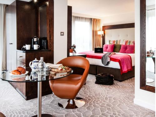a hotel room with a bed and a glass table at The Address Connolly in Dublin