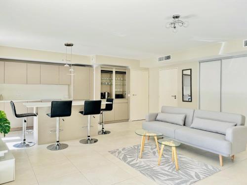 un salon avec un canapé et une cuisine dans l'établissement Le Carré Croisette - Duplex terrasse Centre Cannes, à Cannes