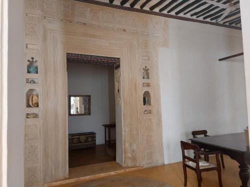 een kamer met een houten deur en een tafel bij Madakani House in Lamu