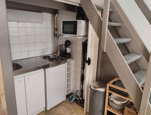 une petite cuisine avec un escalier et un four micro-ondes dans l'établissement Studio en plein cœur de South Pi, à Paris