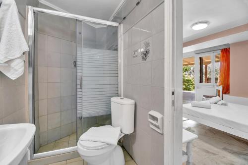 een badkamer met toilet, wastafel en douche bij Tasoula Studio with garden view in Nikiana