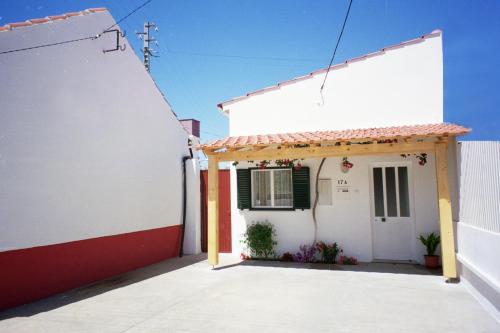 a white house with a red and white wall at Casa Baptista I in Marinha Grande