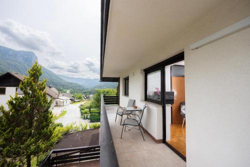a balcony with a table and chairs and mountains at Apartment Panorama & Bella Vista in Bohinjska Bela