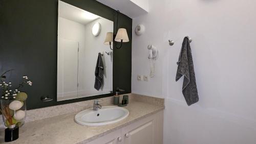 a bathroom with a sink and a mirror at Nouvelle location dans somptueux golf avec piscine, terrains de tennis - situation ++ pour découvrir la Provence in Saumane-de-Vaucluse