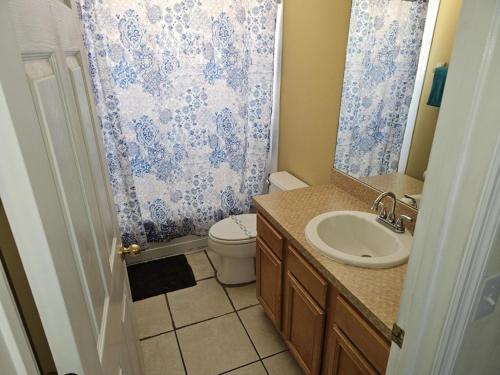 a bathroom with a sink and a toilet and a shower curtain at Spacious 7 BR, 4,5 BR Retreat with Pool 164 condo in Kissimmee