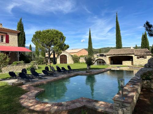 - une piscine dans une cour avec des chaises et une maison dans l'établissement La Meynardière, à Saint-Pierre-de-Vassols