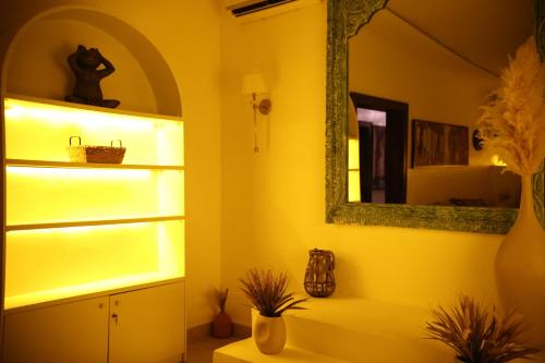 a yellow room with a shelf and a mirror at JOHNWOOD HOTEL by Bolton in Wuse