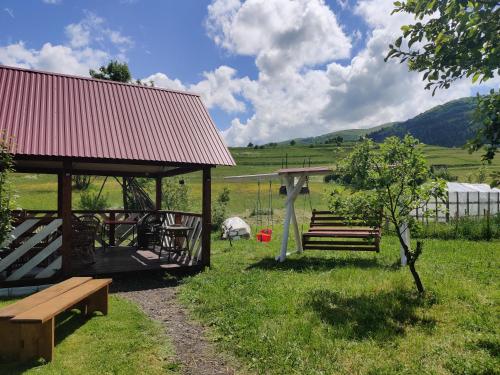 a park with benches and a pavilion in a field at "У Яслигана" in Pilipets