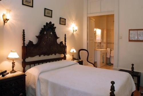 a bedroom with a large bed and a bathroom at Hotel Mira D'Aire in Porto