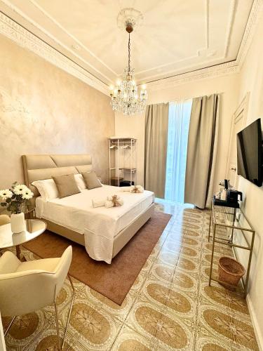 a bedroom with a large white bed and a chandelier at Home To Salerno B&B in Salerno
