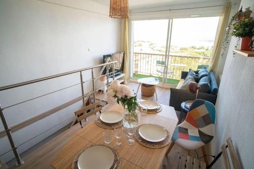 a dining room table with plates and flowers on it at Superb T4 Souplex in Giens in Hyères