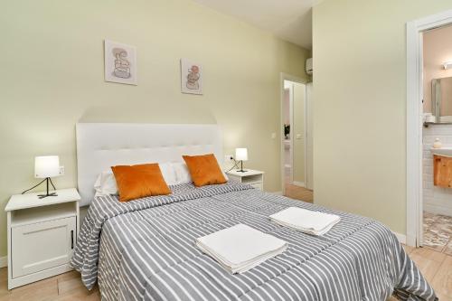 sypialnia z dużym łóżkiem z pomarańczowymi poduszkami w obiekcie Era del puerto 3 w mieście Totalán