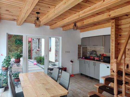 a kitchen and dining room with a wooden ceiling at "У Яслигана" in Pilipets