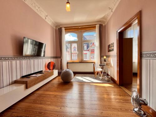 ein Wohnzimmer mit einem TV und einem großen Fenster in der Unterkunft Apartment am Schloss-Park Wiesbaden Biebrich am Rhein in Wiesbaden