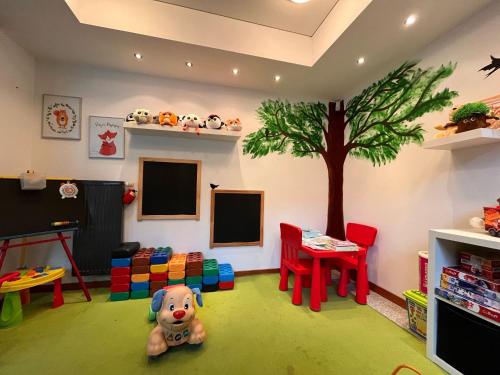 a childs play room with a tree on the wall at 4 Pory Roku Resort Sauna & Spa in Bąkowo