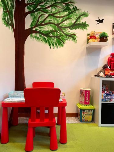 a play room with a table and a tree on the wall at 4 Pory Roku Resort Sauna & Spa in Bąkowo