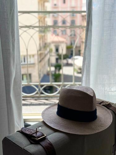 a hat and a pair of sunglasses sitting on a suitcase at Home To Salerno B&B in Salerno