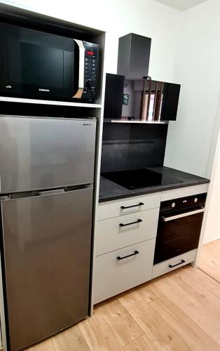 a kitchen with a microwave and a stove top oven at Ma Bulle d Aix superbe studio tout confort in Aix-les-Bains