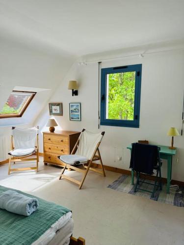une chambre avec un lit, un bureau et une fenêtre dans l'établissement Port Manec'h, superbe maison au dessus de la plage, à Névez