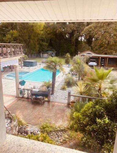 - une vue aérienne sur une piscine bordée de palmiers dans l'établissement Magnifique, villa avec Piscine, à Dax
