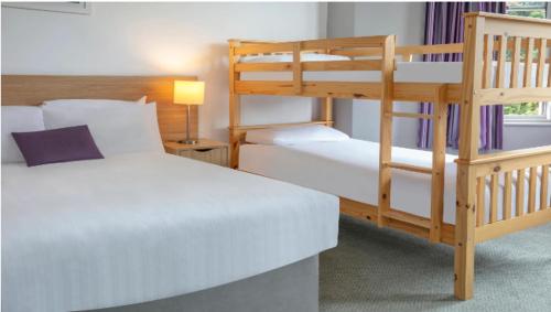 a bedroom with two bunk beds and a lamp at Tor Park Hotel in Torquay