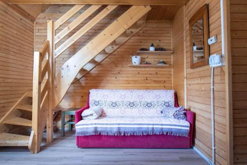 Habitación con sofá rojo en una casa de madera en Cabin Storzek, en Hočko Pohorje