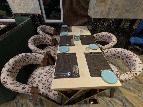 a table with chairs around it in a restaurant at AR Plaza in Chandīgarh