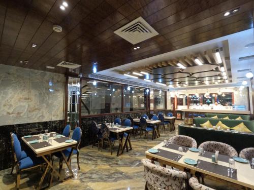 a restaurant with tables and chairs and a bar at AR Plaza in Chandīgarh