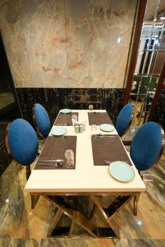 a table with blue chairs around it in a room at AR Plaza in Chandīgarh