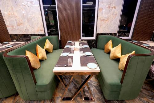 a dining room with a table and green chairs at AR Plaza in Chandīgarh
