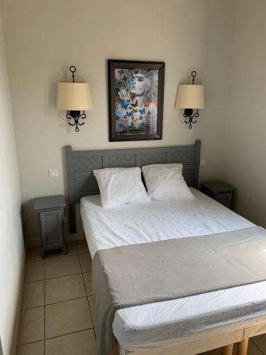 - une chambre avec un lit et deux lampes murales dans l'établissement Maison duplex - Domaine P&V Le Rouret - Proche Vallon Pont d'Arc, à Grospierres