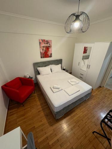 1 dormitorio con 1 cama y 1 silla roja en The Nest, en Tesalónica