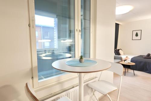 a small table and chairs in a room with a window at Flamingo Studio, Free Parking, 2 Min to Airport and Spa in Vantaa