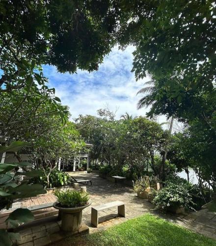 a park with a bench and trees and a sky at The Postcard Galle in Galle