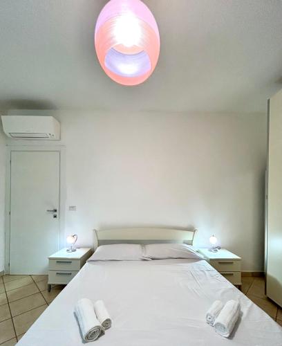 Un dormitorio con una cama con dos toallas encima. en Nura's - Casa Flor Seaside, en Alghero