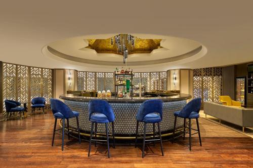 un vestíbulo con un bar con taburetes azules en Sheraton Imperial Kuala Lumpur Hotel, en Kuala Lumpur