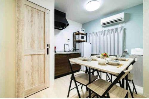a kitchen with a table with chairs and a refrigerator at 55, Kameido-Suijin, Entire house for rent, 亀戸水神 in Tokyo