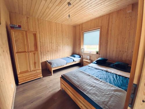 sypialnia z 2 łóżkami w drewnianym domku w obiekcie Zielona Dolina Sarbinowo w Sarbinowie