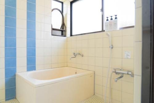 a bath tub in a bathroom with a window at Kinoie guesthouse 3rd buildingーVacation STAY 26705v in Mito