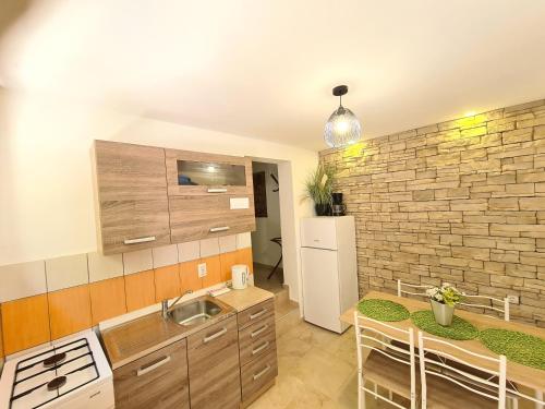 a kitchen with a sink and a table with chairs at Apartments Helena Pomer in Pomer