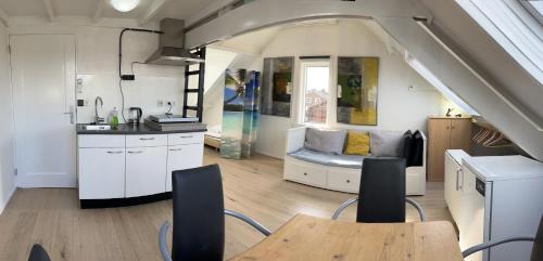 奈梅亨的住宿－Studio met eigen badkamer en eigen keuken，厨房以及带桌子和沙发的客厅。