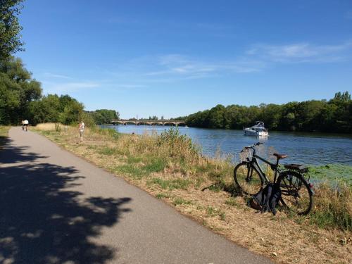 a bike parked on the side of a path next to a river at The Great Wave, appartement calme avec terrasse et parking gratuit in Ban-Saint-Martin