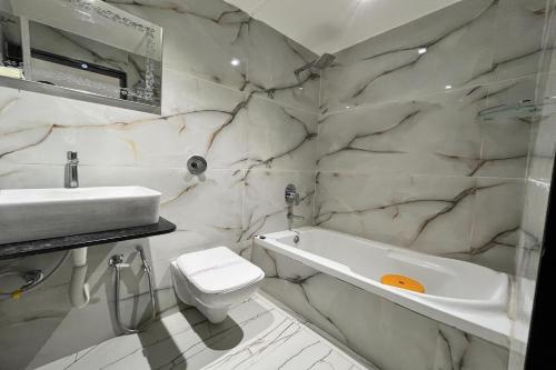 ein Badezimmer mit einem Waschbecken, einer Badewanne und einem WC in der Unterkunft HOTEL SHAILLY INN in Ahmedabad