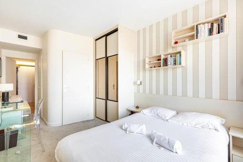 une chambre avec un lit blanc et un bureau dans l'établissement GuestReady - Beau Séjour près de la Tour Eiffel, à Paris