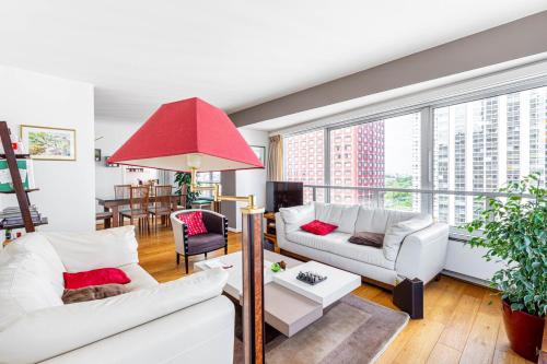 un salon avec des meubles blancs et une grande fenêtre dans l'établissement GuestReady - Beau Séjour près de la Tour Eiffel, à Paris