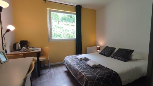 een slaapkamer met een bed, een bureau en een raam bij Neoresid - Résidence du Parc in Reims