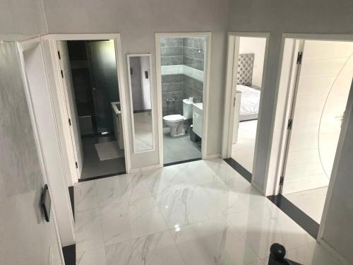 a white bathroom with a toilet and a sink at Splendide Villa, Marrakech in Marrakesh