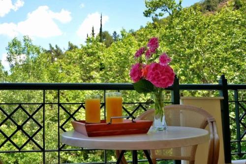 a table with a vase of flowers on a balcony at Archontiko tou Ziaka in Ipáti