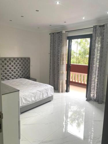 a bedroom with a bed and a large window at Splendide Villa, Marrakech in Marrakesh
